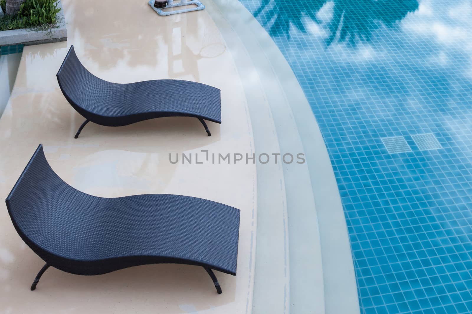 Beach chairs near swimming pool, top view
