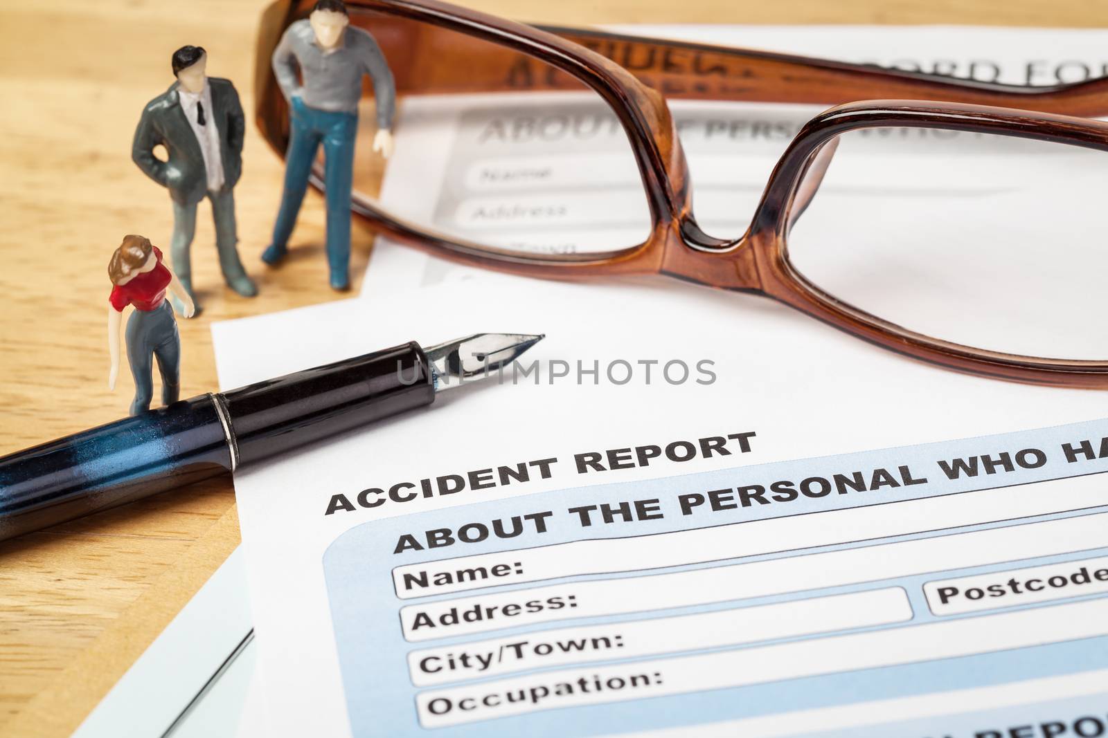 Accident report application form and pen on brown envelope and eyeglass, business insurance and risk concept; document is mock-up