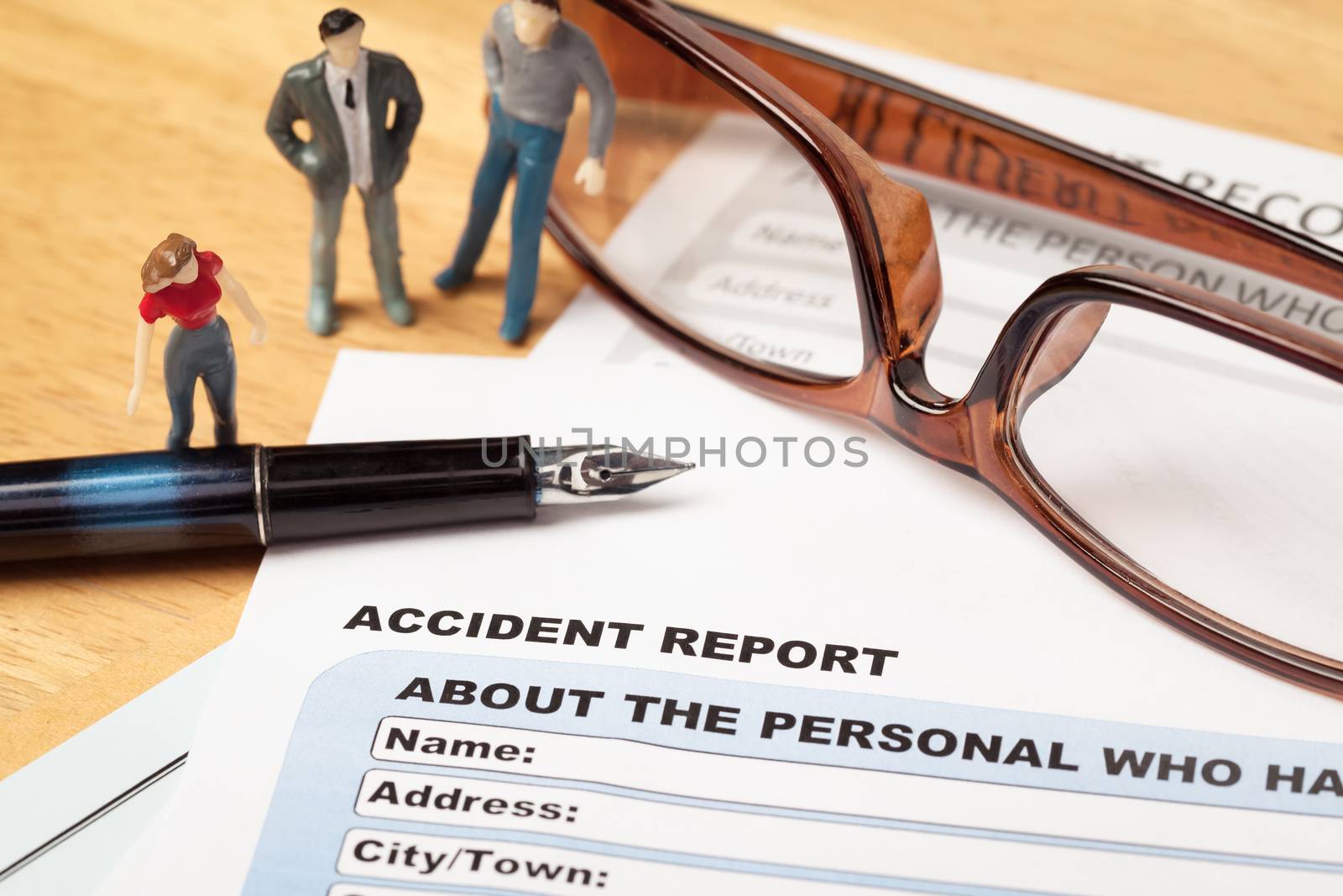 Accident report application form and pen on brown envelope and eyeglass, business insurance and risk concept; document is mock-up