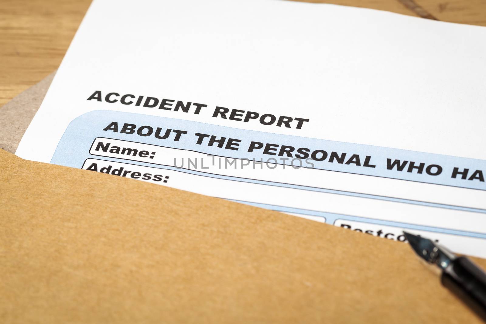 Accident report application form and pen on brown envelope, business insurance and risk concept; document is mock-up