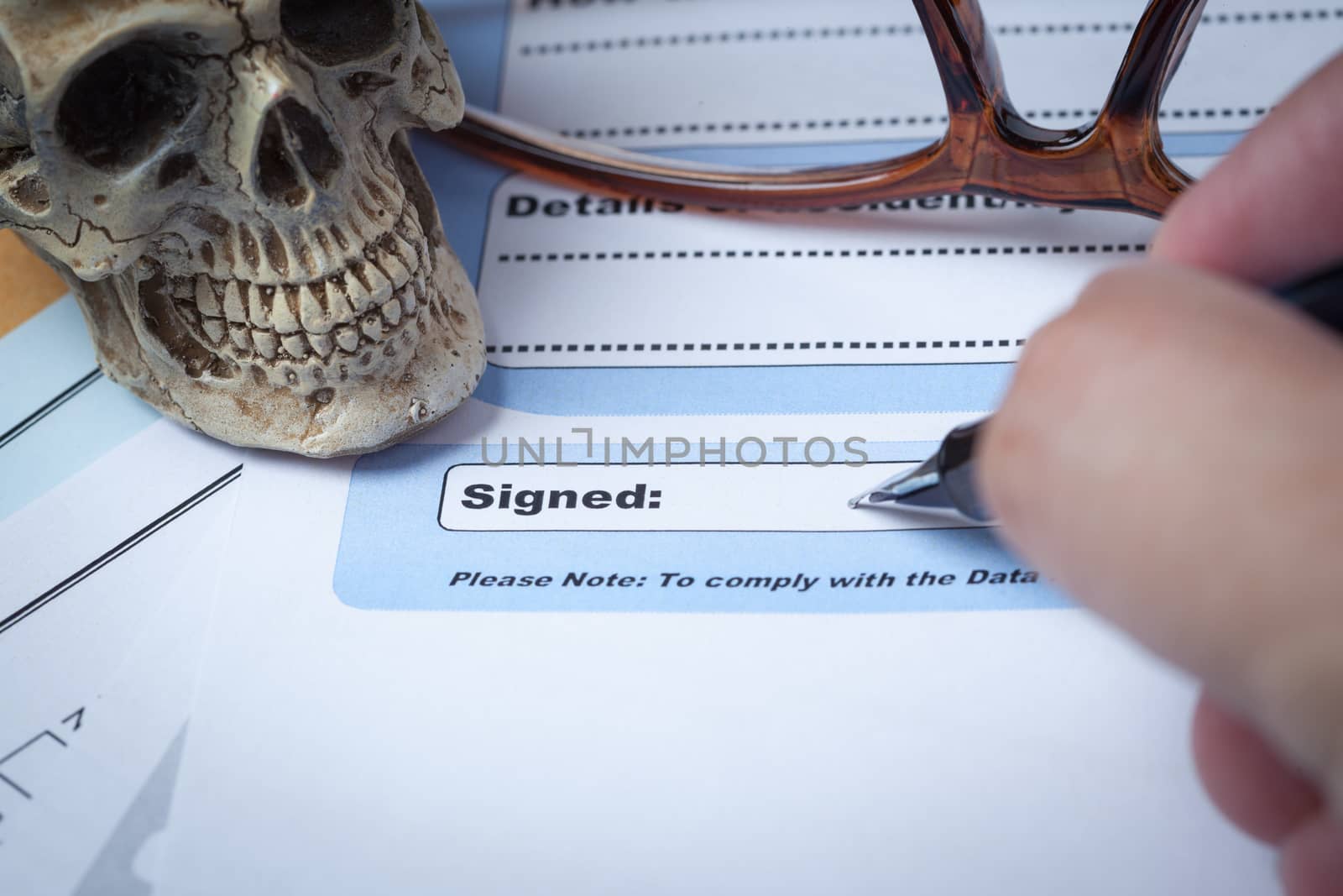 Signature field on document with pen and skull signed here; docu by FrameAngel