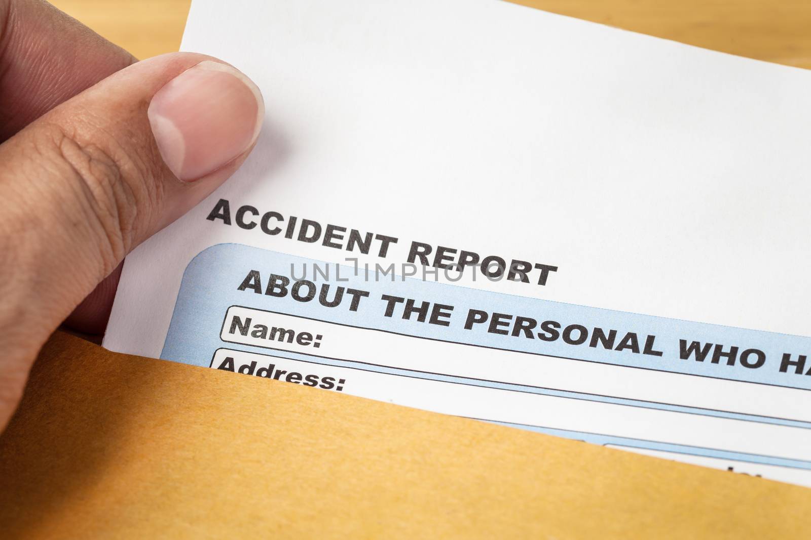 Accident report application form and human hand on brown envelope, business insurance and risk concept; document is mock-up