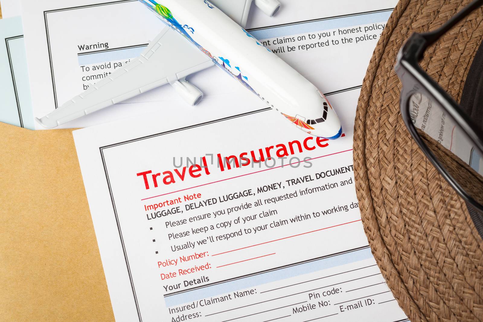 Travel Insurance Claim application form and hat with eyeglass on by FrameAngel