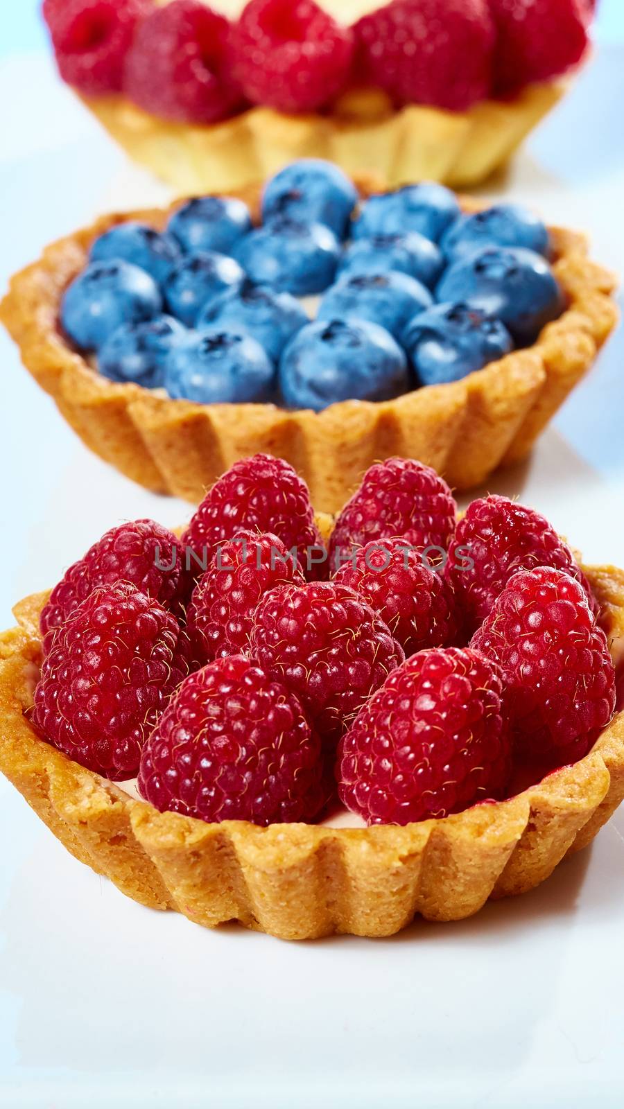 fruit tartlets with raspberries and blueberries. with copy space