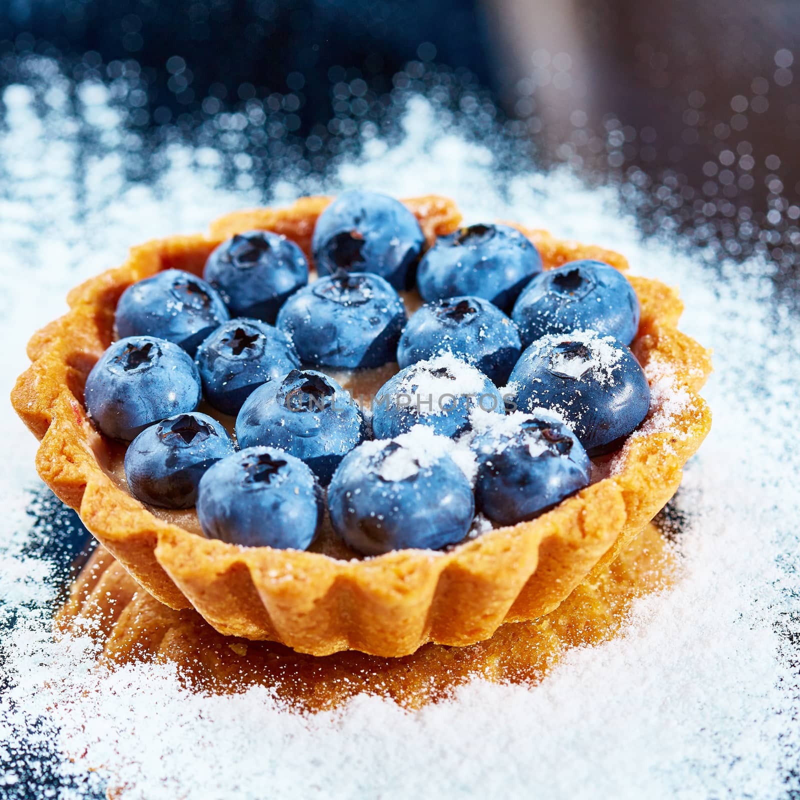 Tartlet with fresh blueberries. Background with copy space.