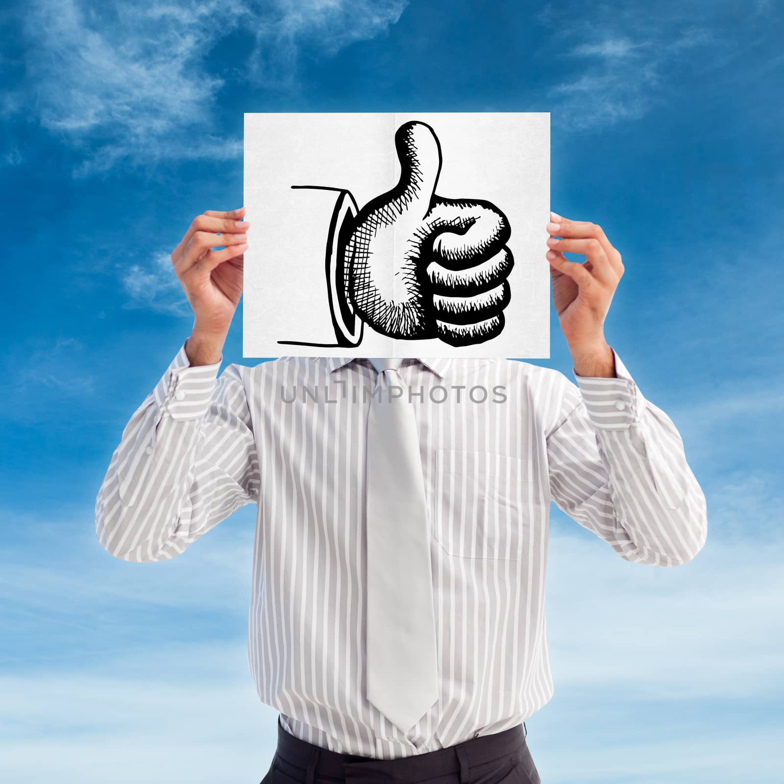 Businessman holding a white card covering his face against blue sky