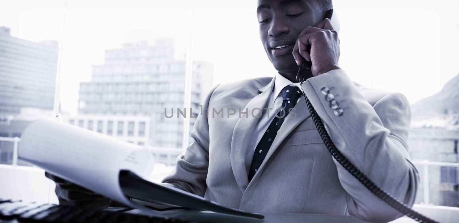 Businessman on the phone while reading a document by Wavebreakmedia