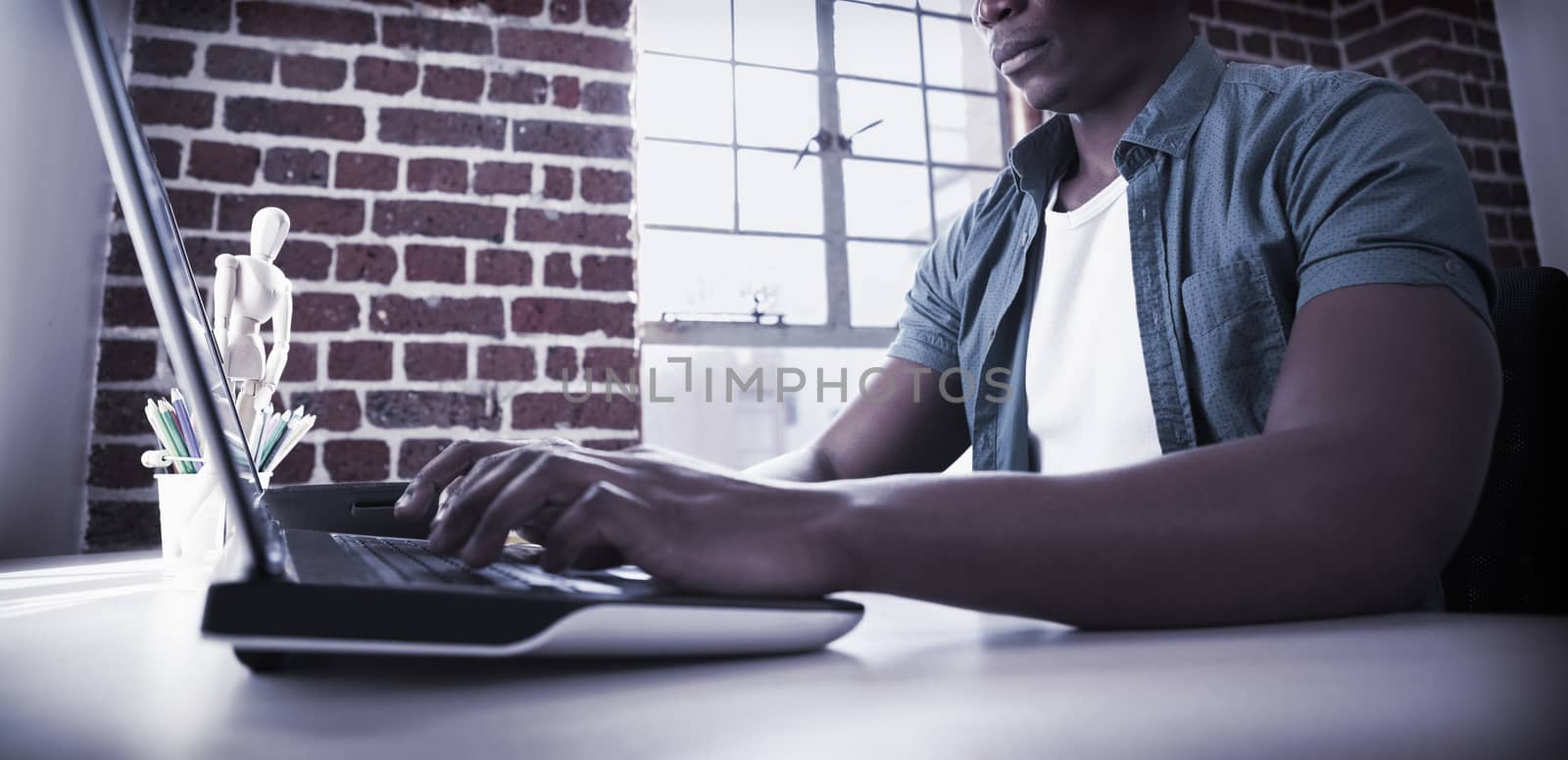 Casual businessman working on laptop at desk in the office