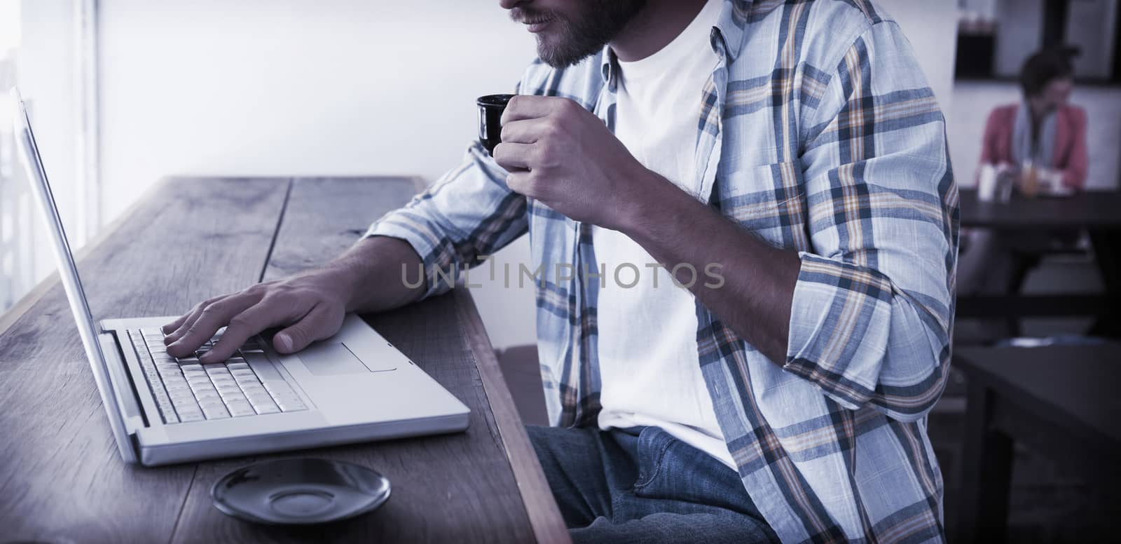 Casual man using laptop drinking espresso at the coffee shop