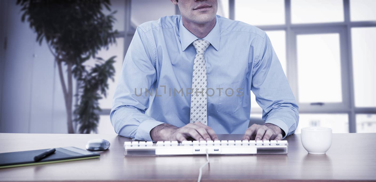 Businessman typing at his desk by Wavebreakmedia