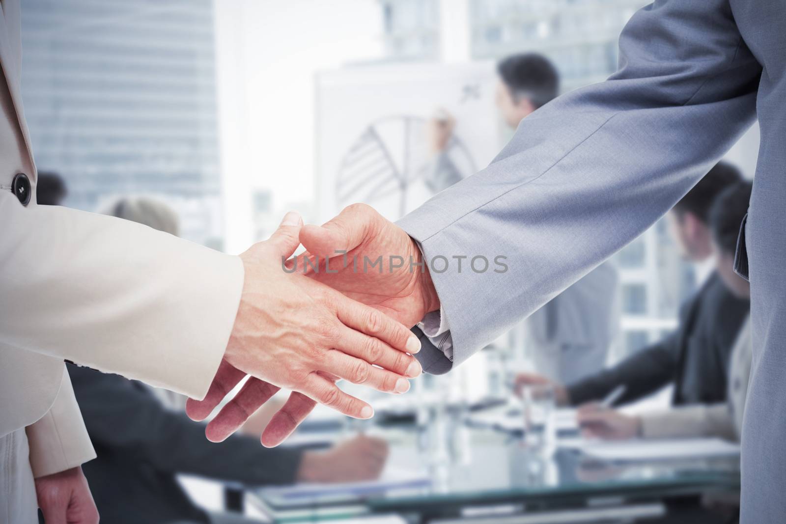 Close up of business people shaking their hands against business people in office at presentation
