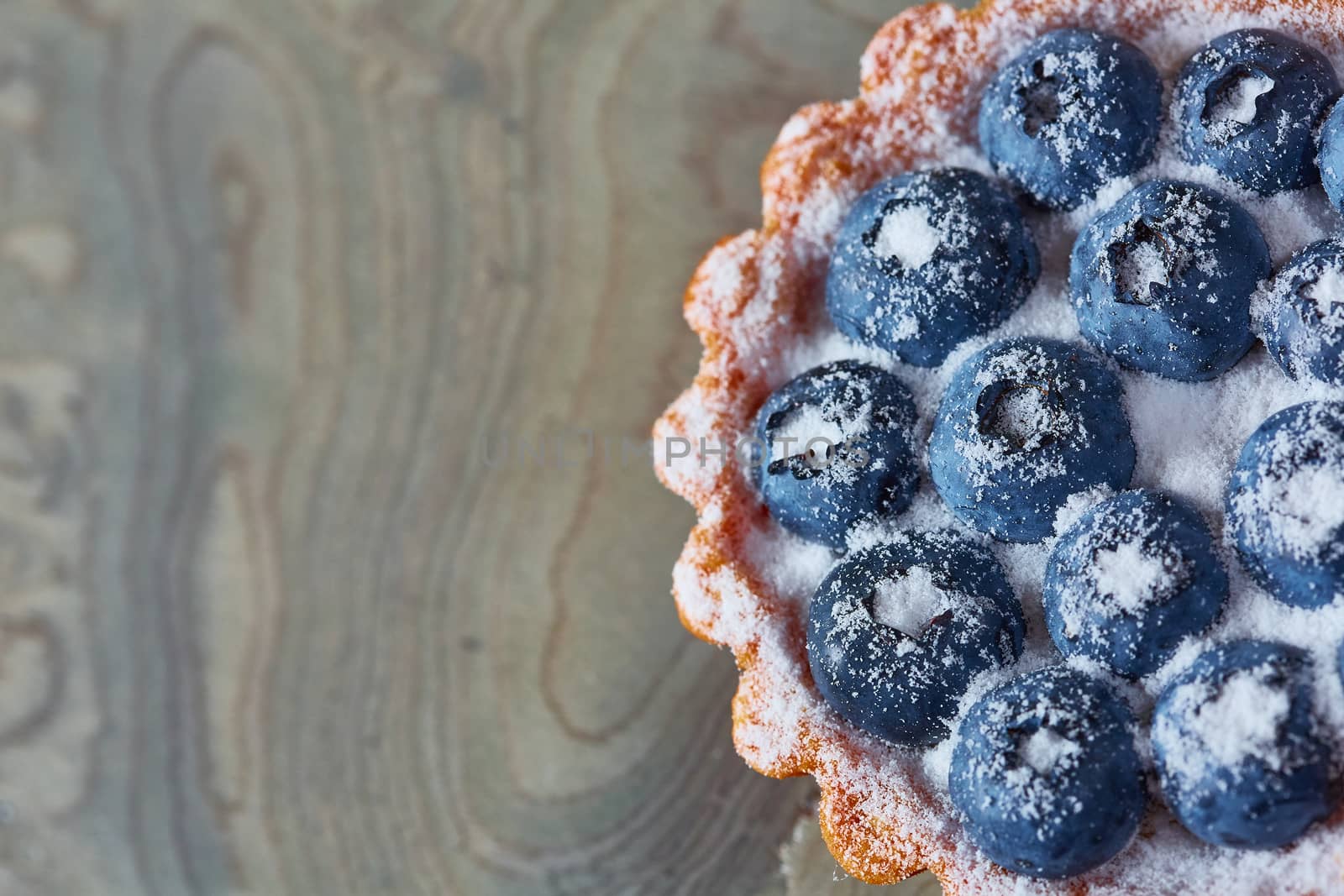 Tartlet with fresh blueberries. Background with copy space.