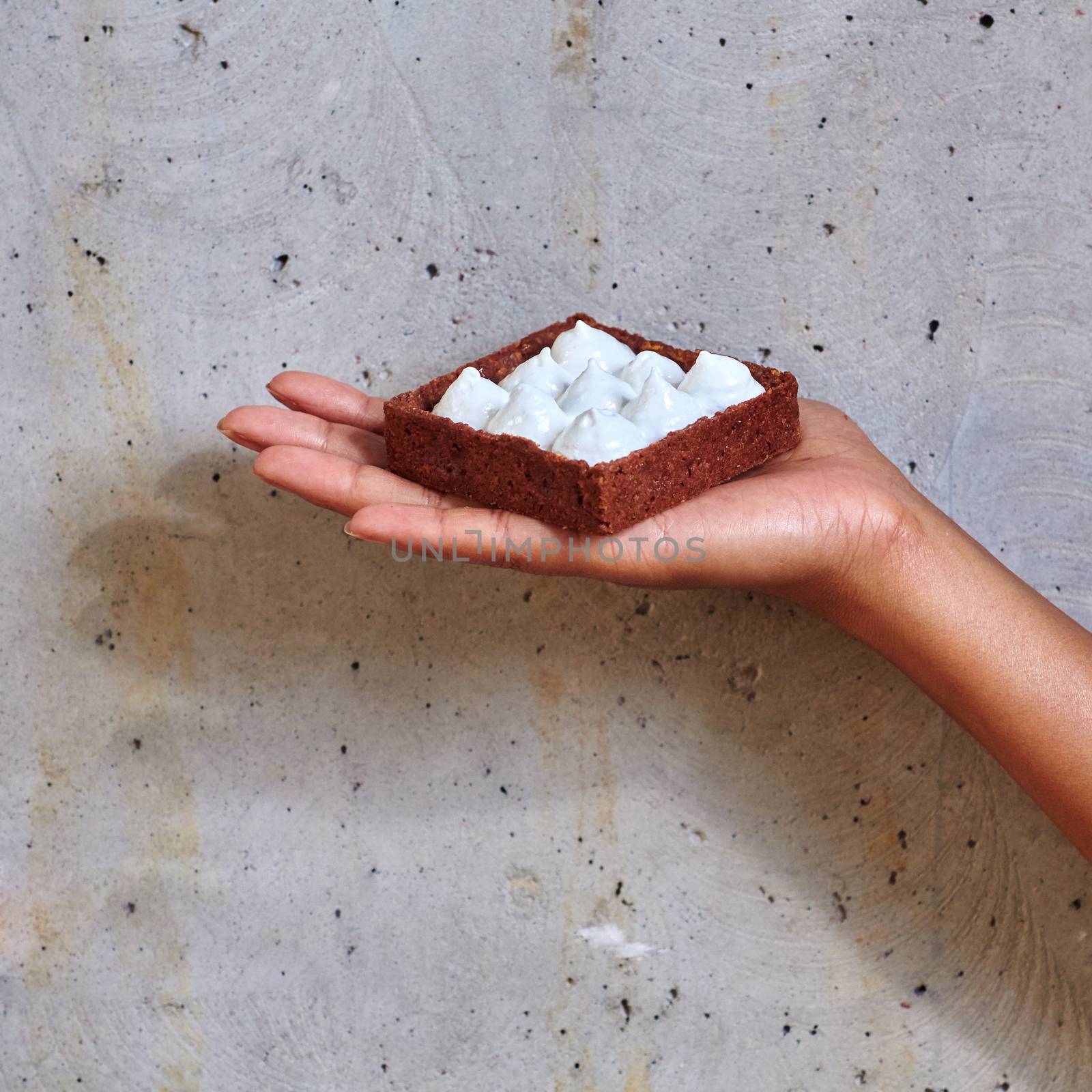 Dessert in a hand on a concrete background with copy space