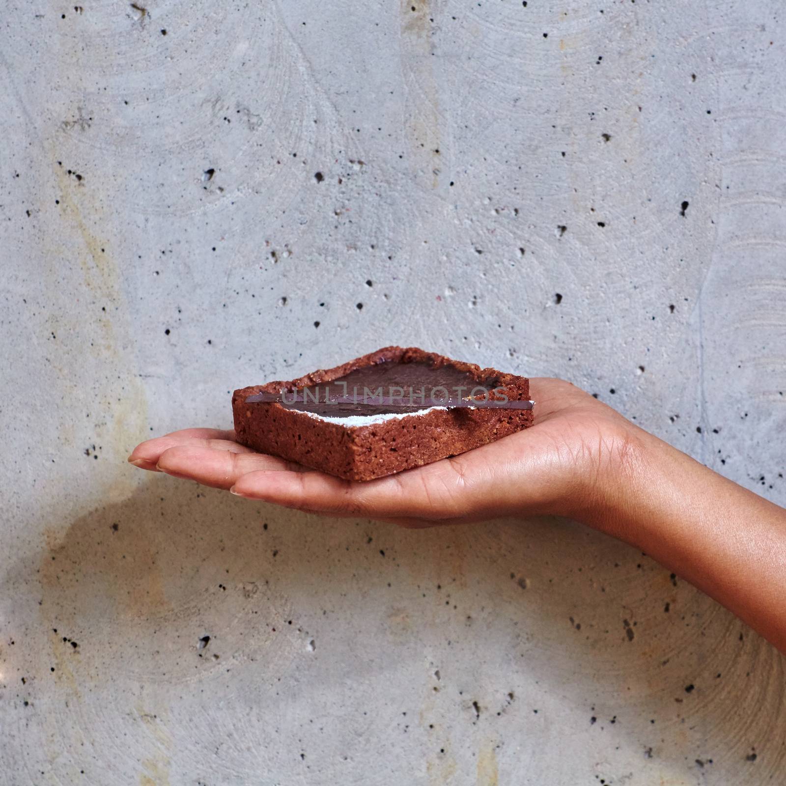 Dessert in a hand on a concrete background with copy space