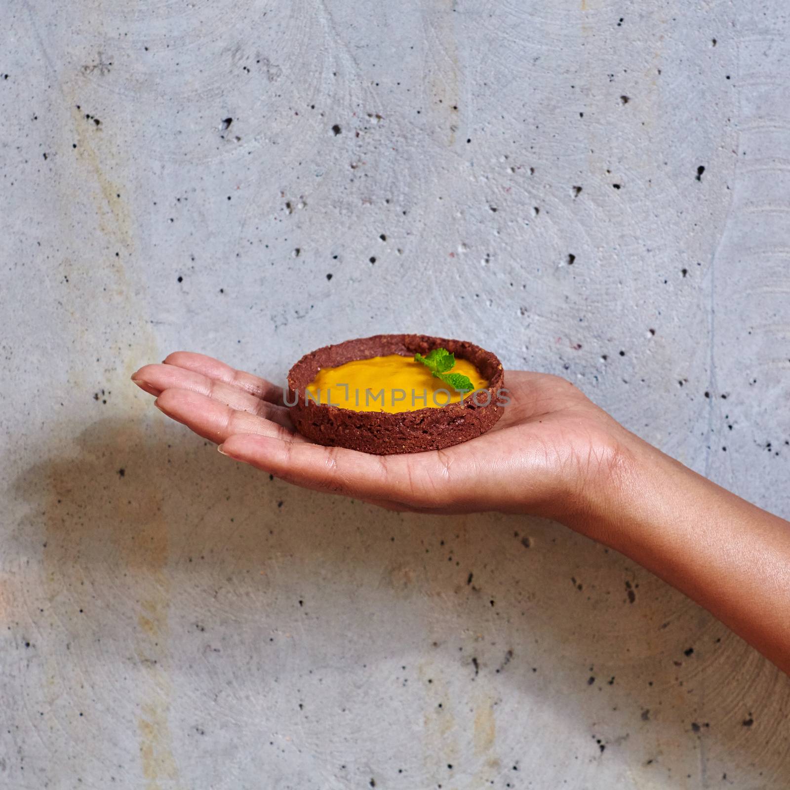 Dessert in a hand on a concrete background with copy space