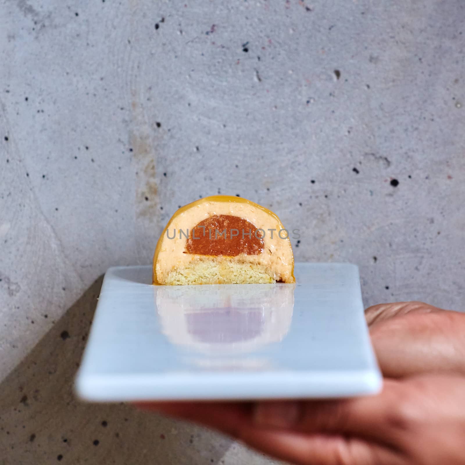 Dessert in a hand on a concrete background