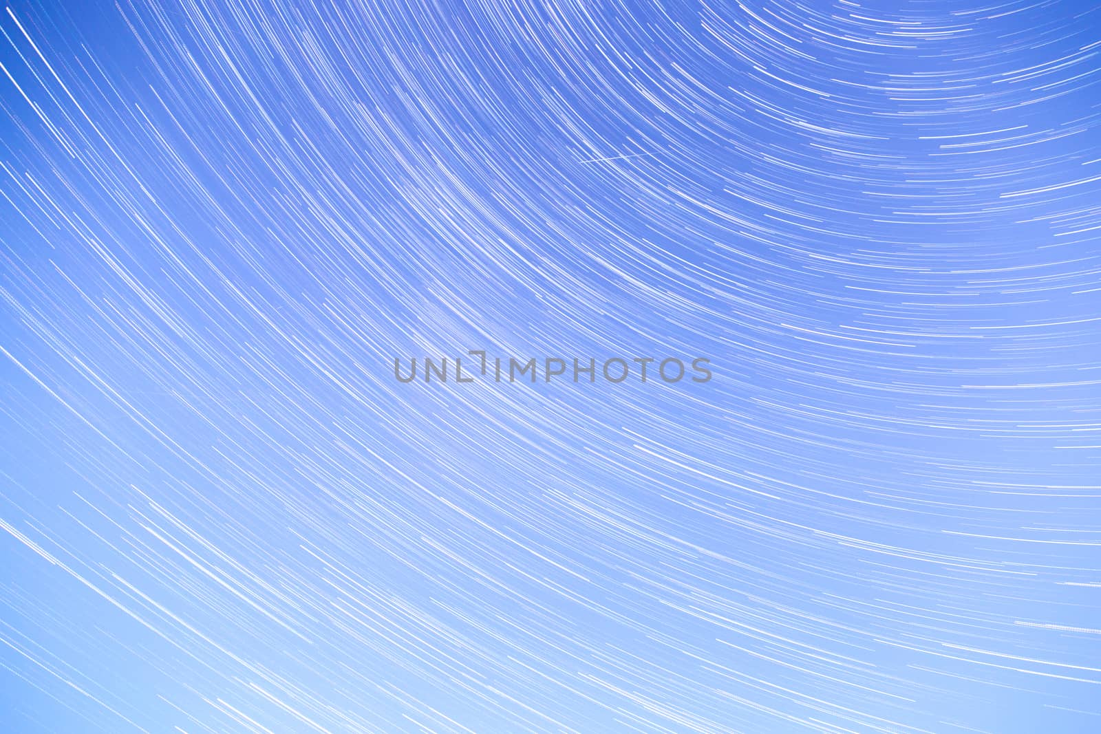 Star Trails streaking across a Blue Sky.