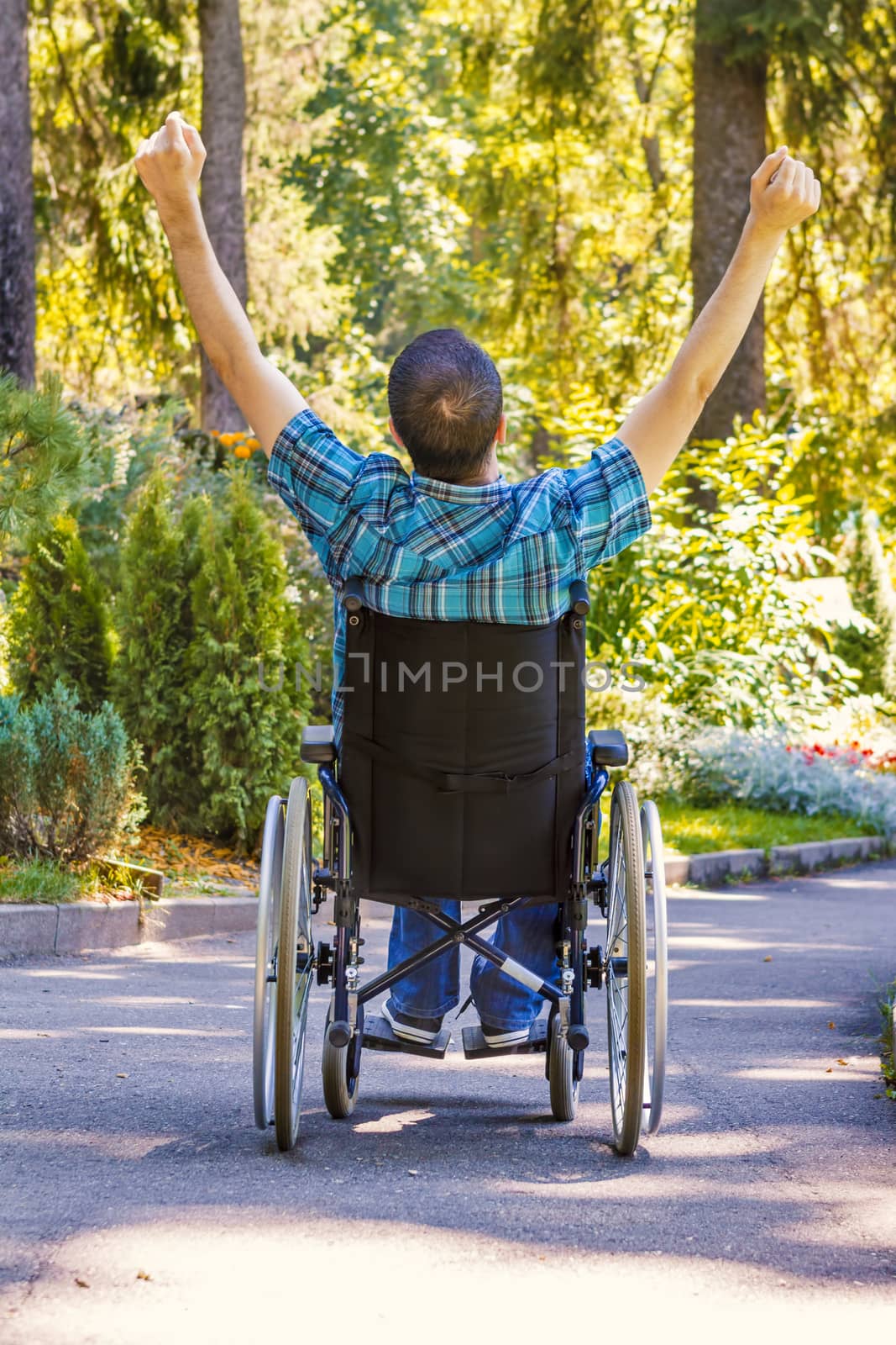 young man in wheelchair with wide opened arms by manaemedia