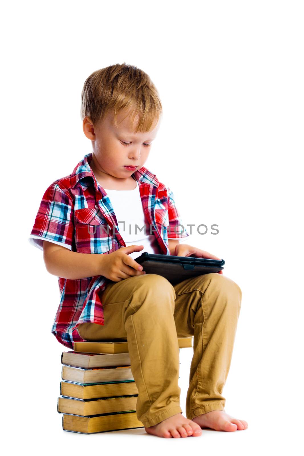 boy with a Tablet PC sitting on the books by pzRomashka