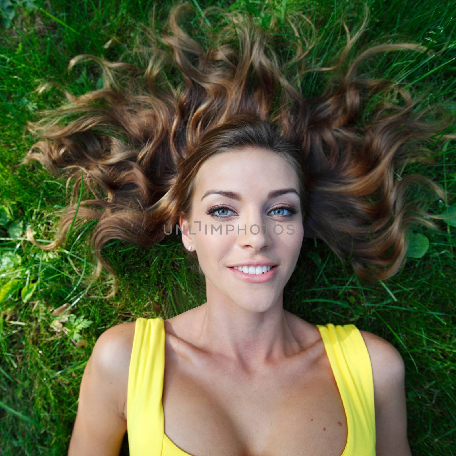 young woman in yellow dress lying on grass by Yellowj