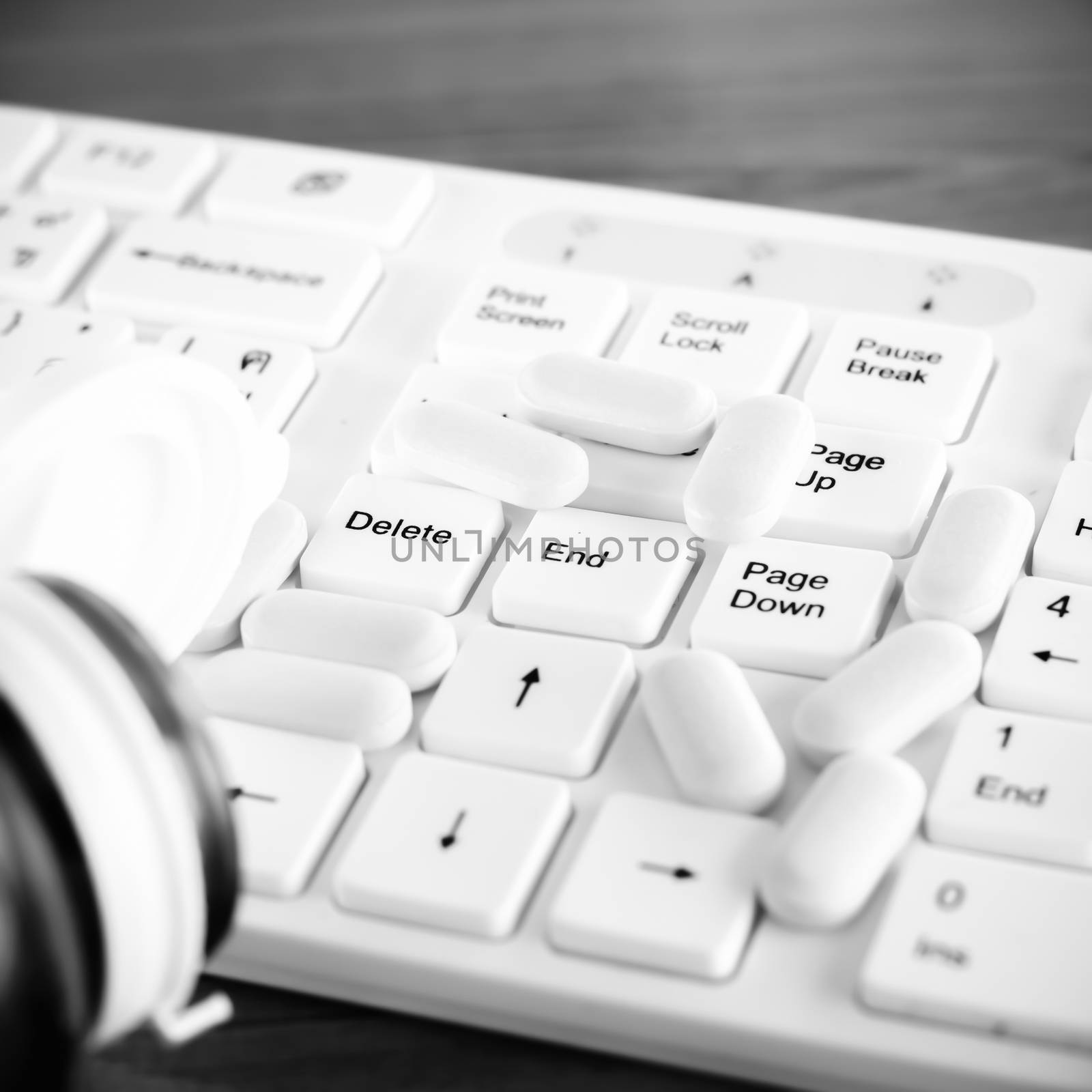 pills on keyboard computer on wooden background concept technology addiction black and white color tone style