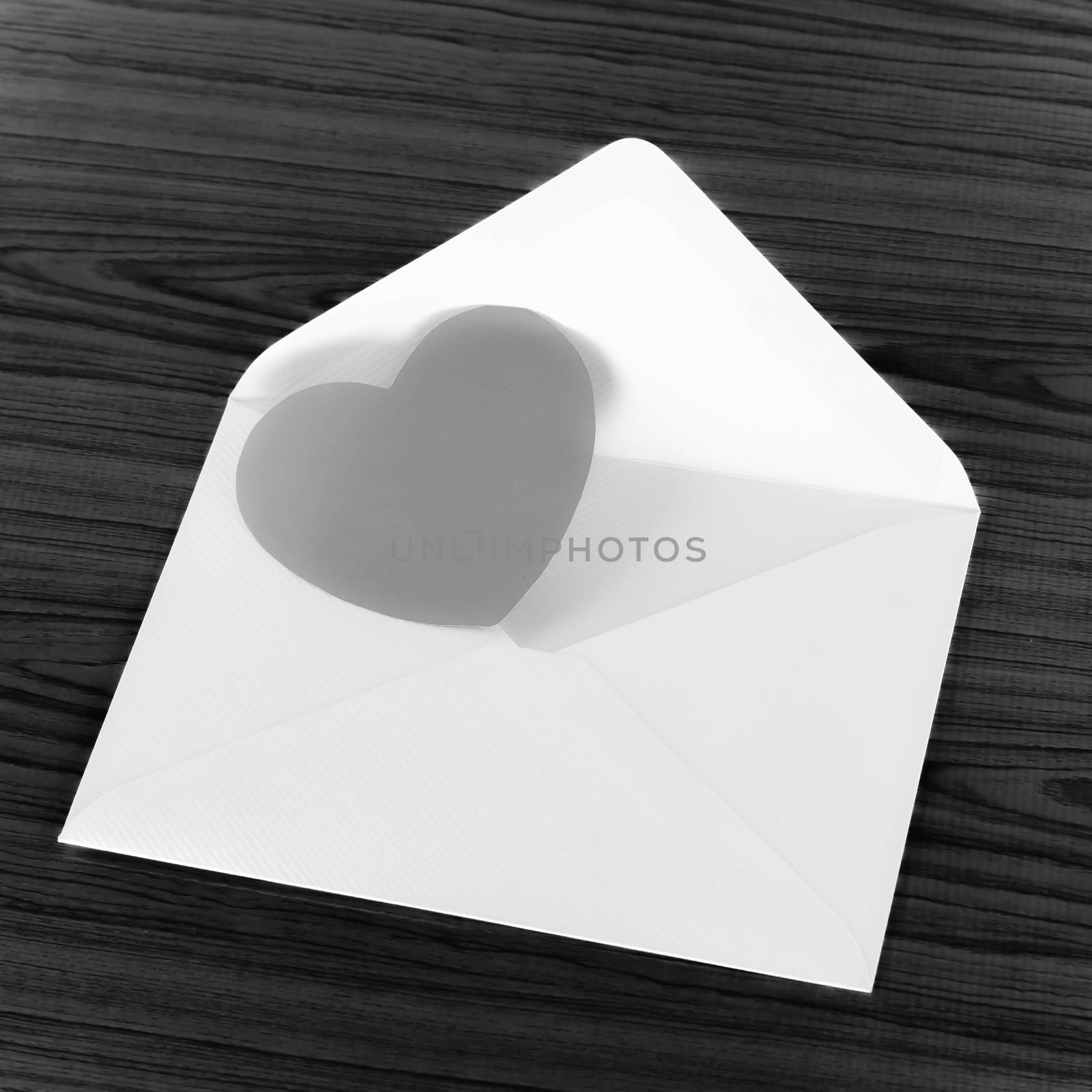 heart with envelope on wooden background black and white color tone style