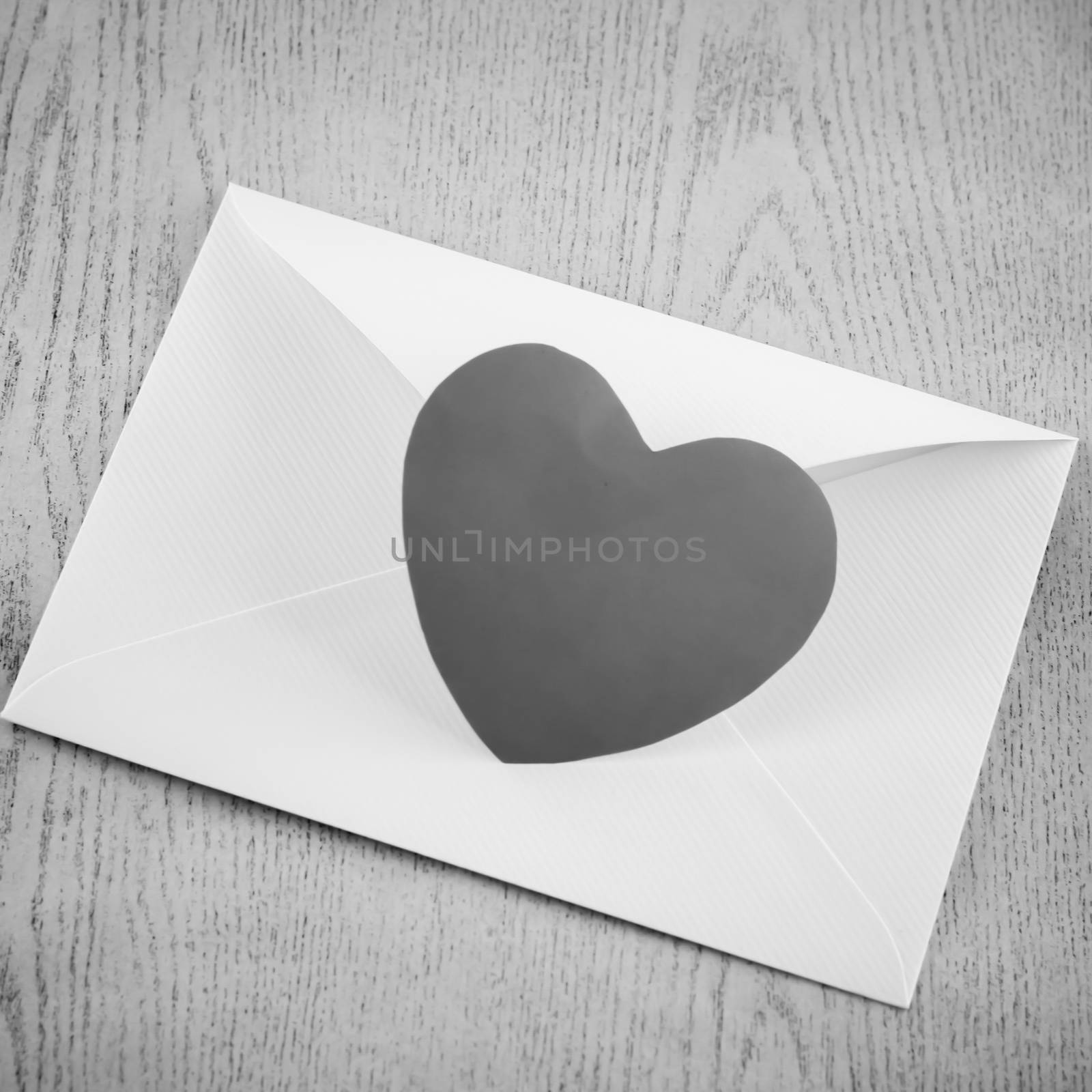 heart with envelope on wooden background black and white color tone style