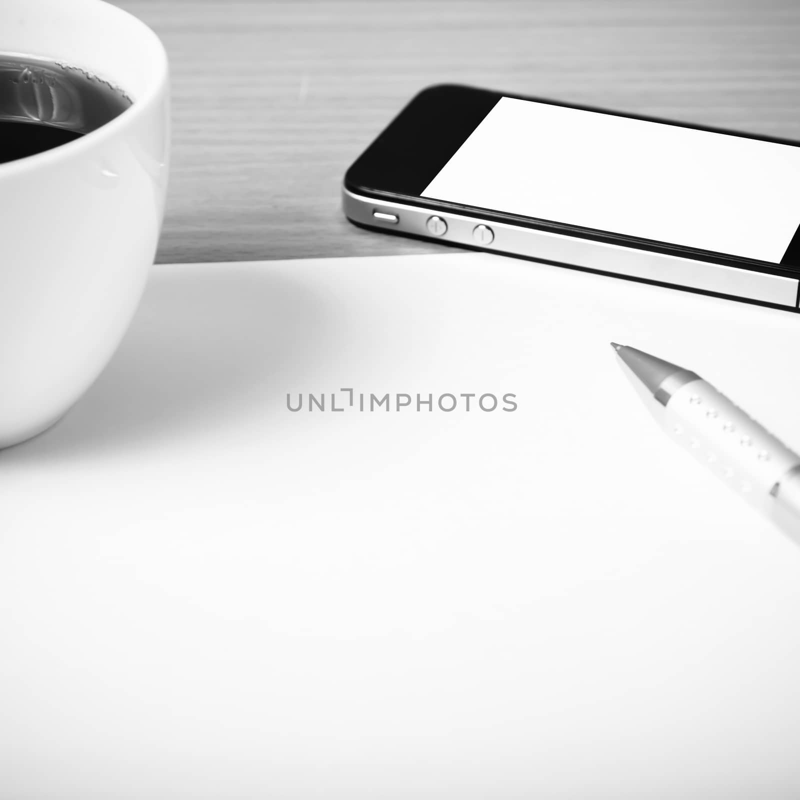 paper and pen with coffee cup and smart phone on wood background black and white color tone style