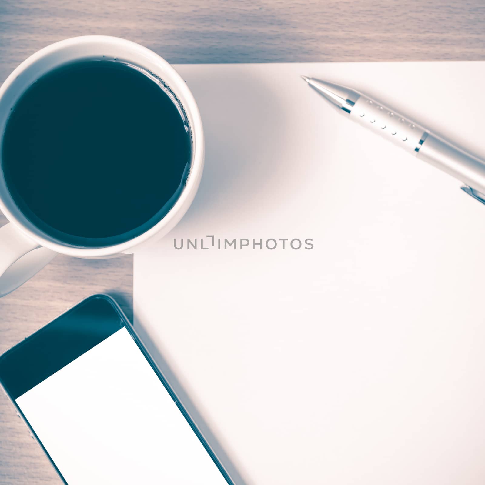 paper and pen with coffee cup and smart phone on wood background vintage style