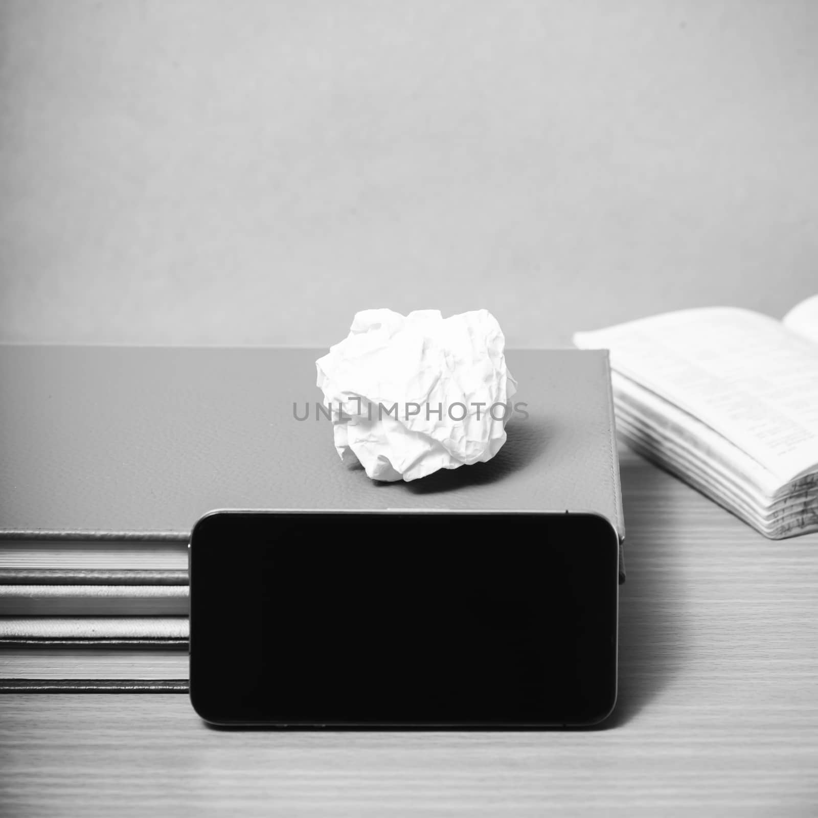 stack of book with smart phone on wood background black and white color tone style