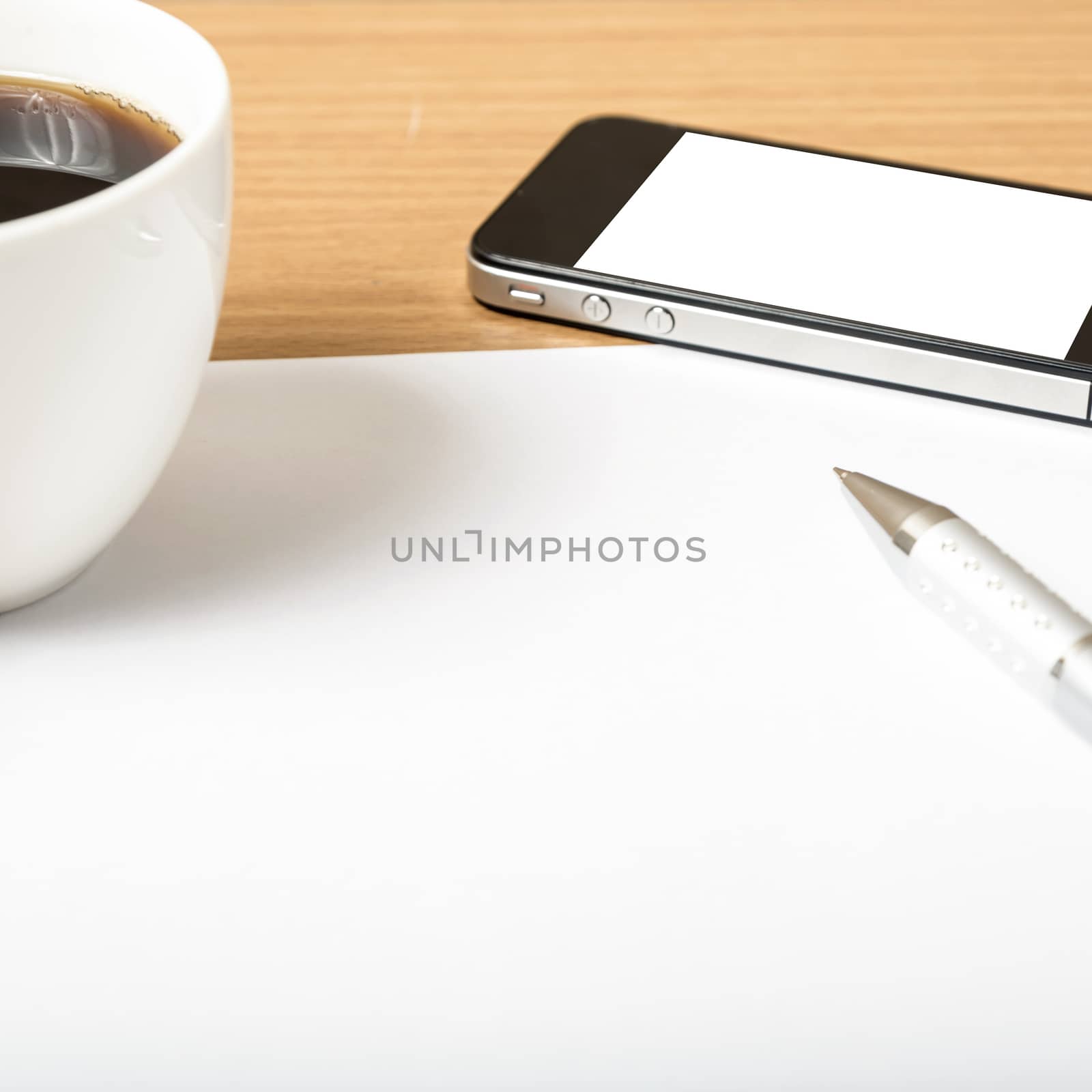 paper and pen with coffee cup and smart phone on wood background