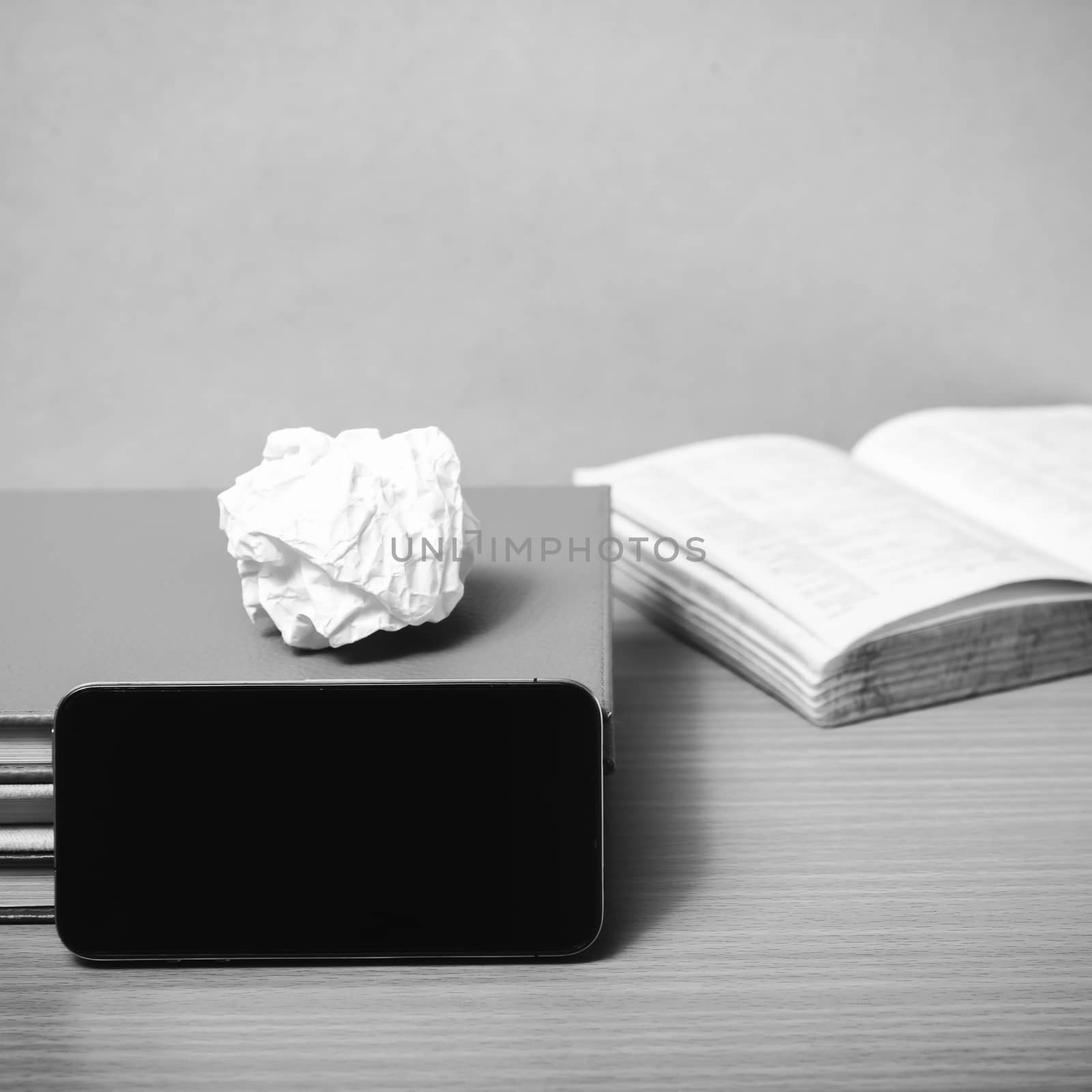 stack of book with smart phone on wood background black and white color tone style