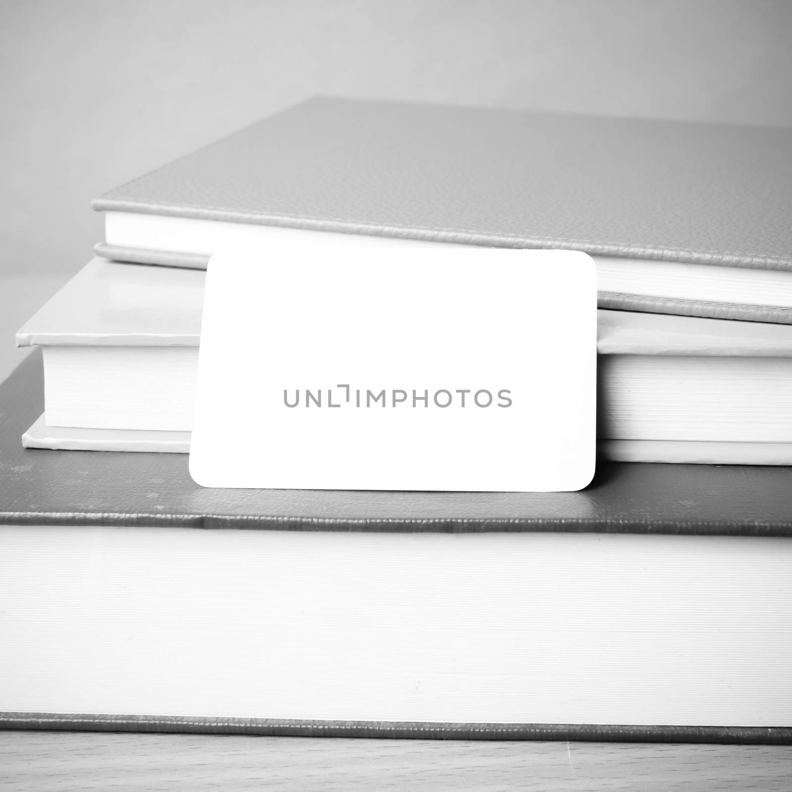 stack of book and business card on wood background black and white color tone style