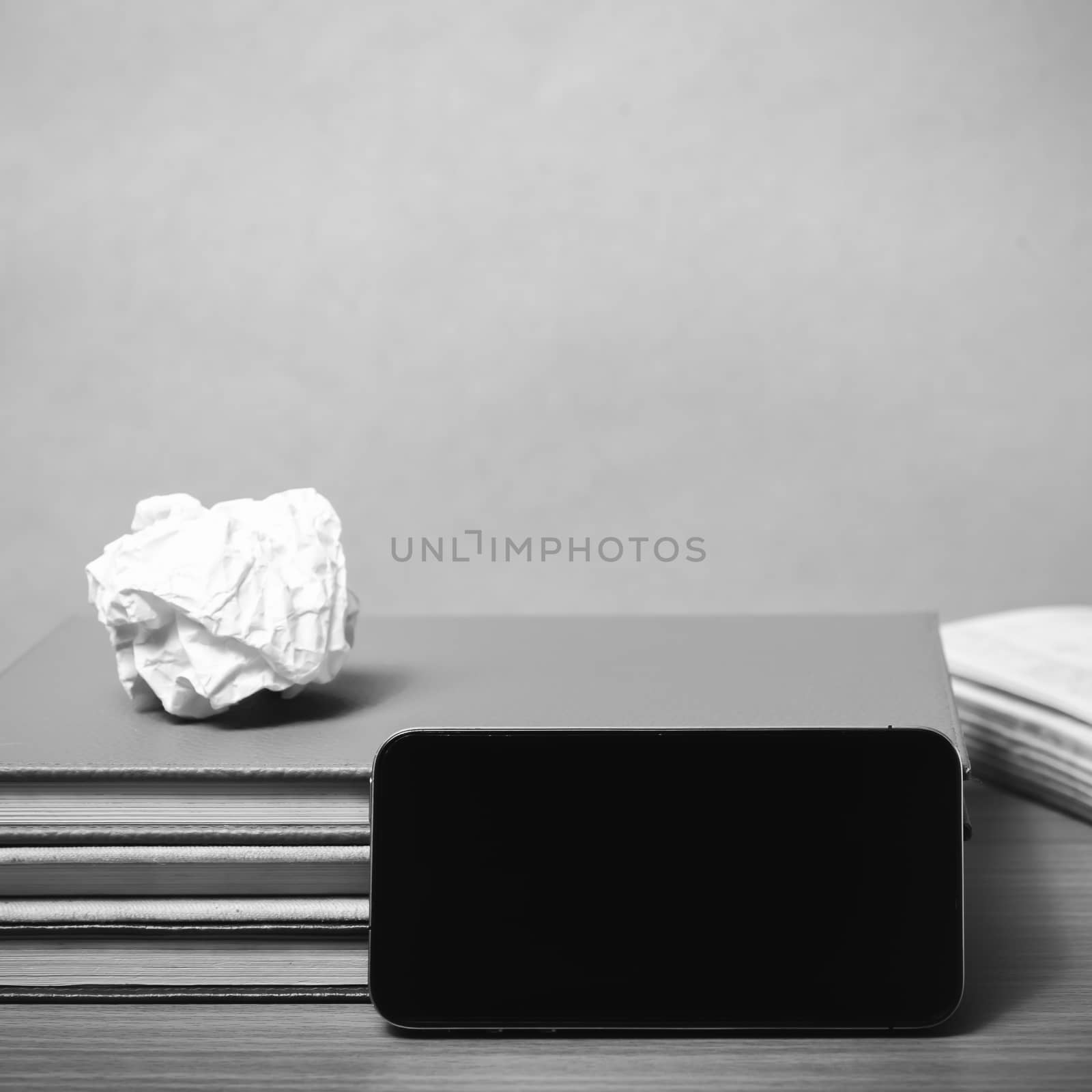 stack of book with smart phone on wood background black and white color tone style