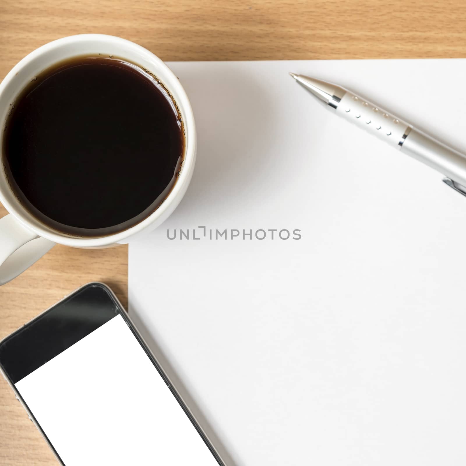 paper and pen with coffee cup and smart phone on wood background