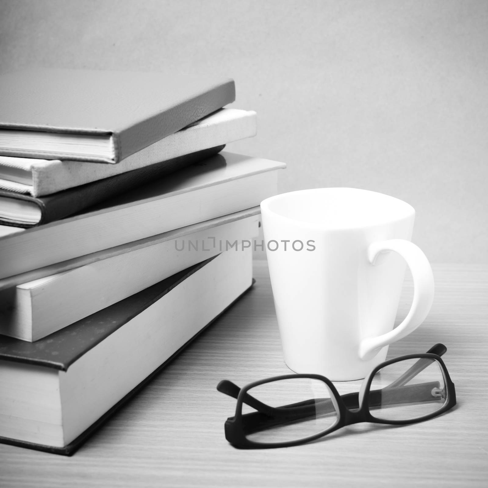 stack of book with coffee mug on wood background black and white tone style