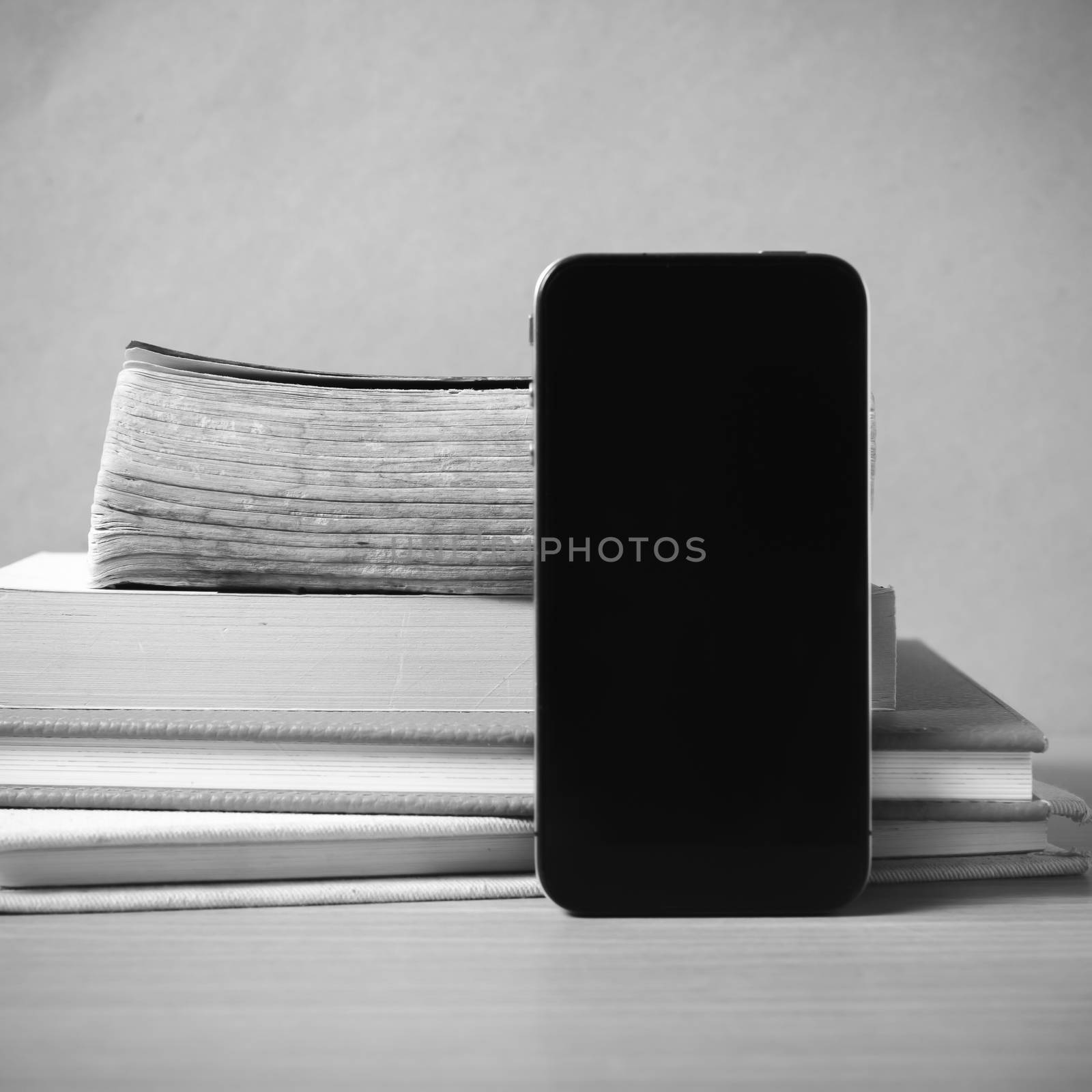 stack of book and smart phone black and white color tone style by ammza12
