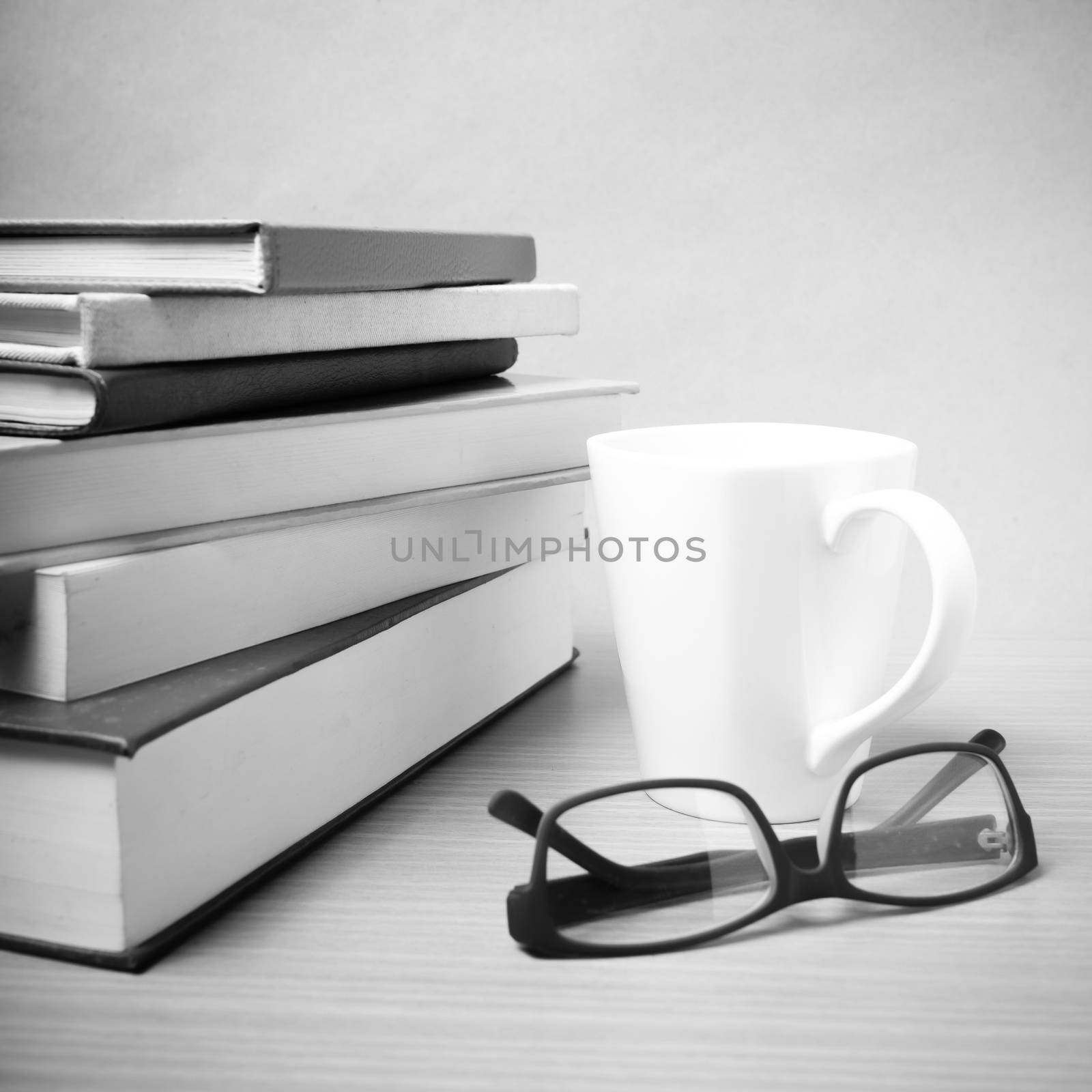 stack of book with coffee mug on wood background black and white tone style