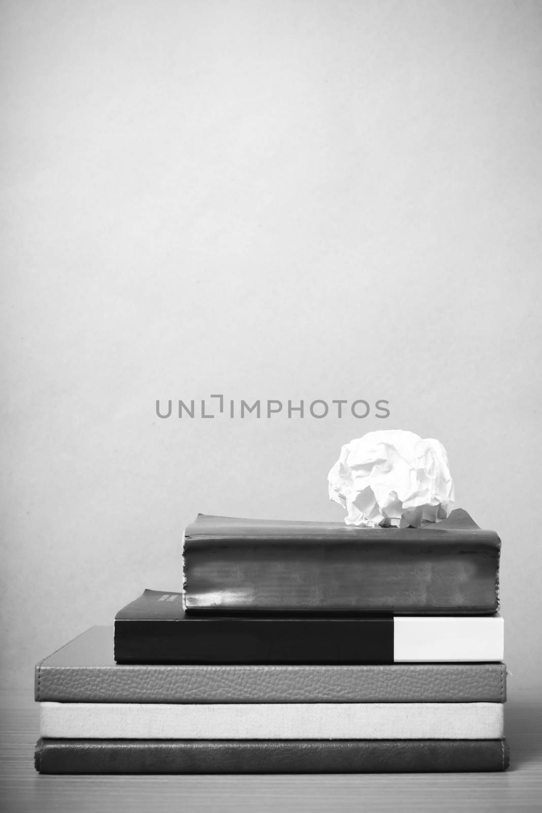 book and crumpled paper on wood background black and white color tone style