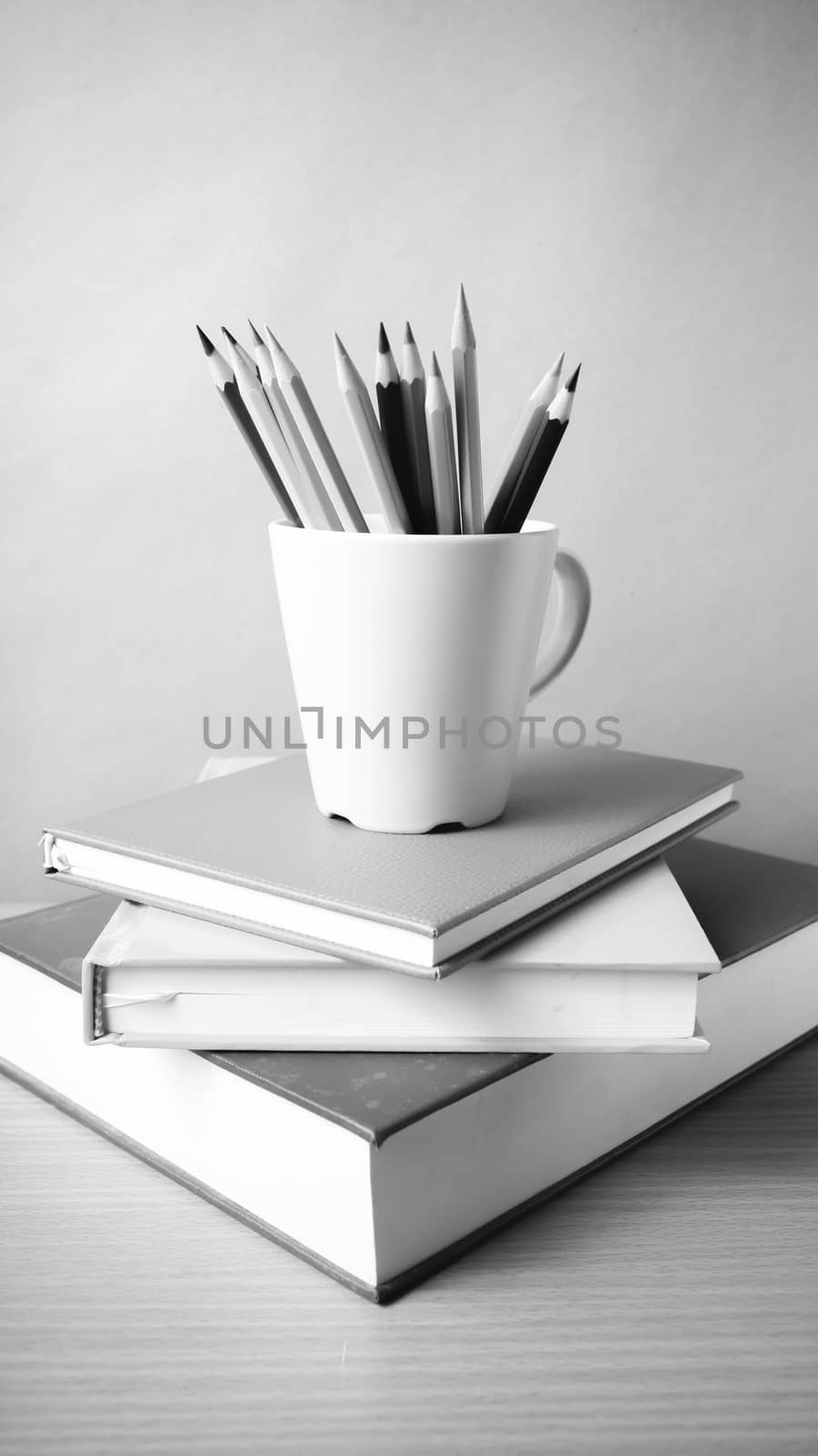 stack of book with pencil on wood table background black and white color tone style