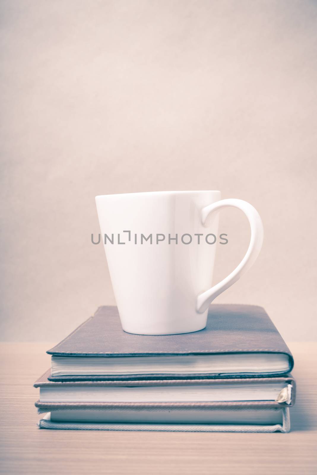 stack of book with coffee mug on wood background vintage style