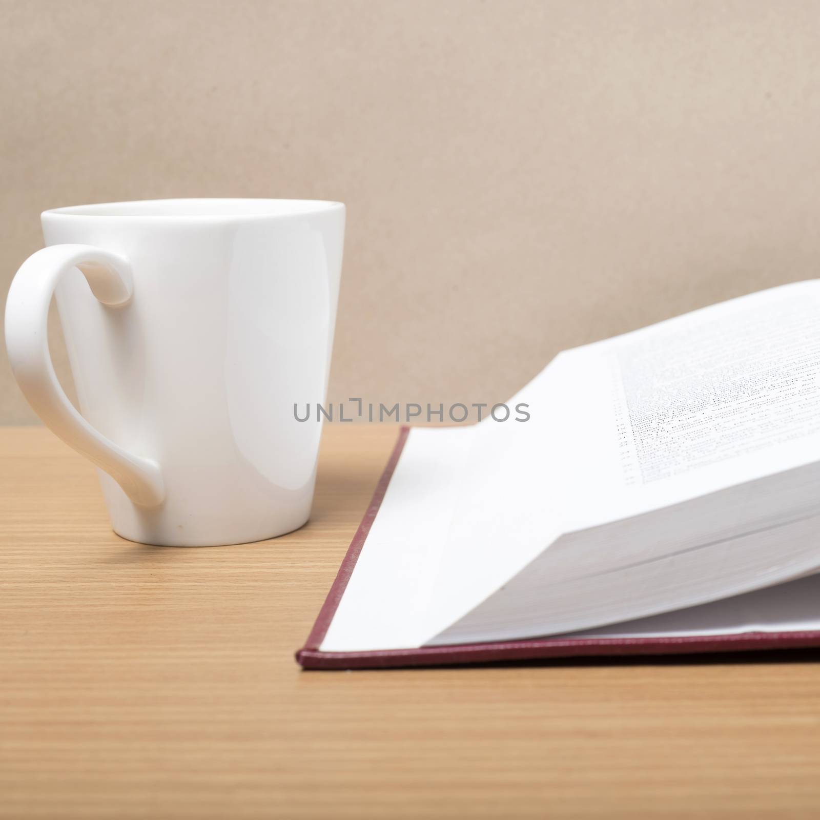 book and coffee mug on wood background