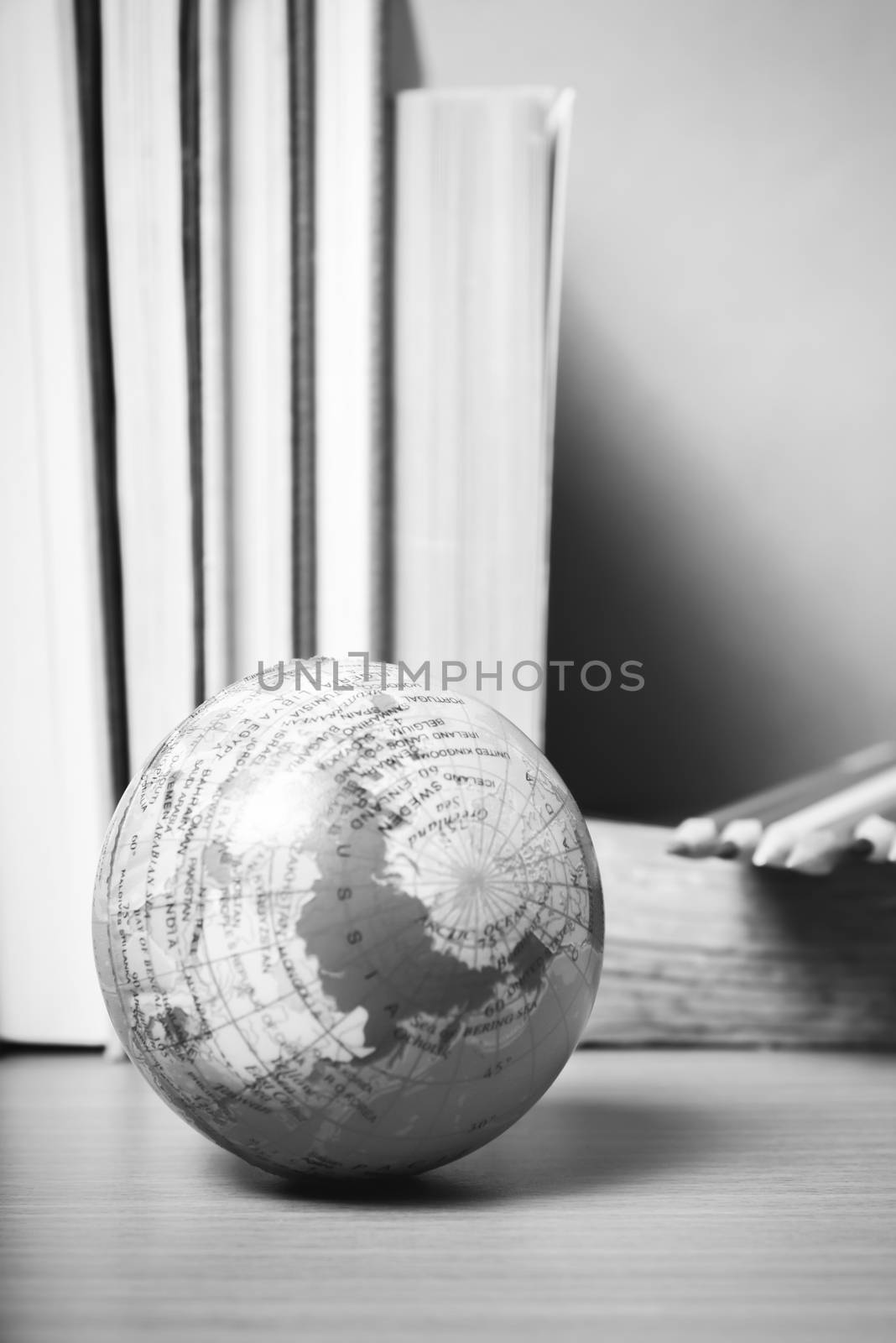 book and earth ball with color pencil on wood background black and white color tone style