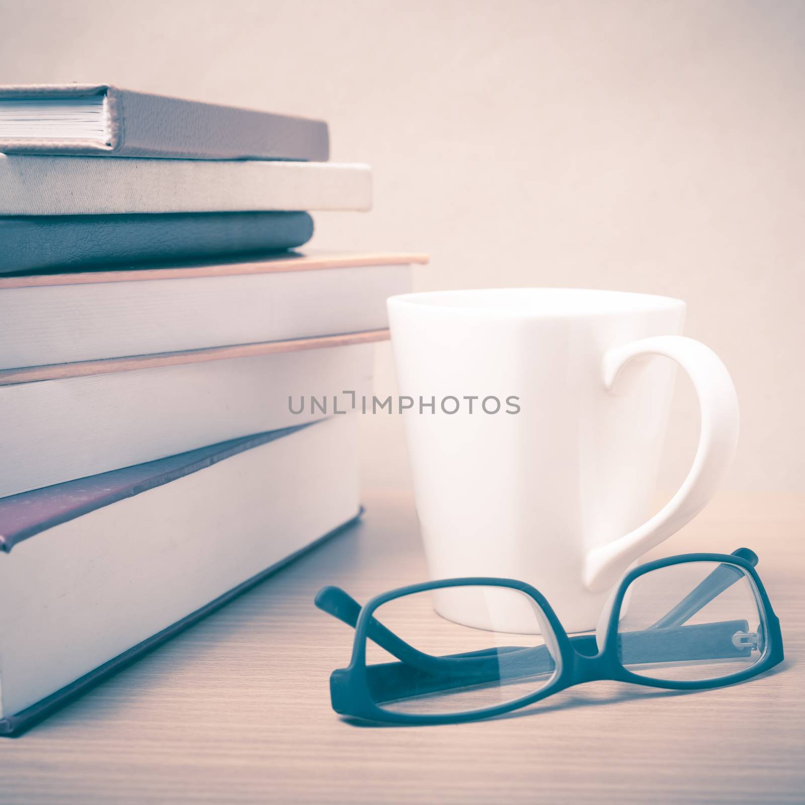 stack of book with coffee mug on wood background vintage style