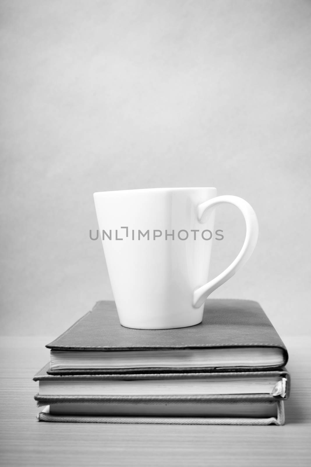 stack of book with coffee mug on wood background black and white tone style