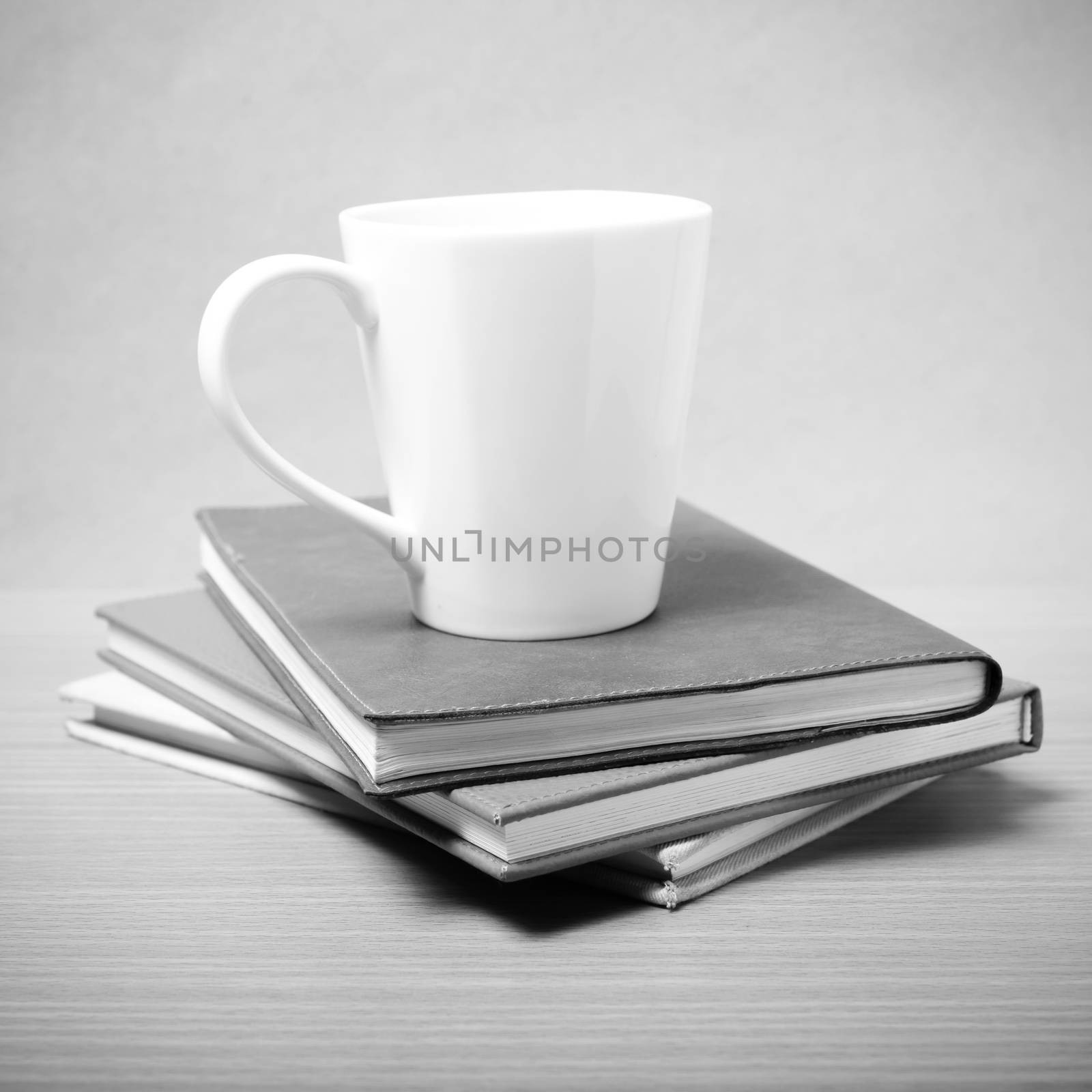 stack of book with coffee mug on wood background black and white tone style