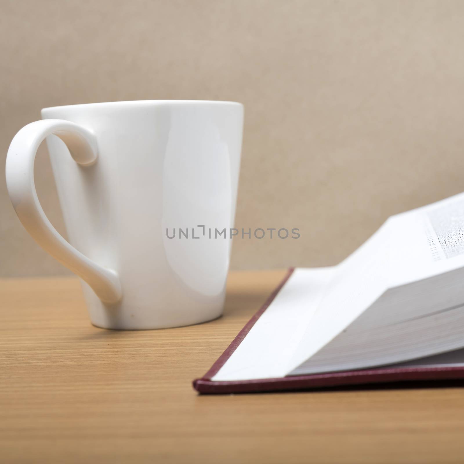 book and coffee mug on wood background
