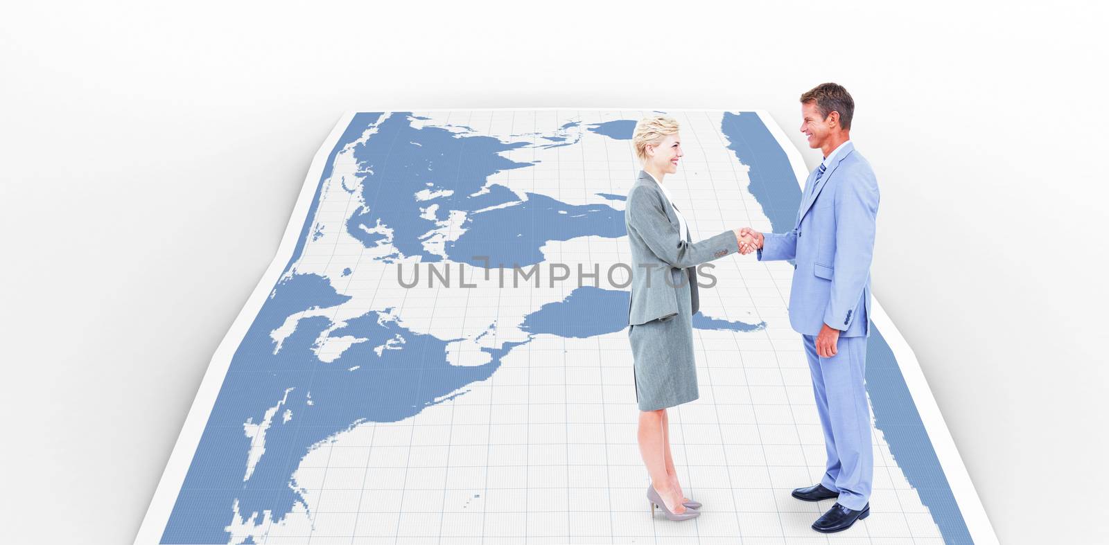 Smiling business people shaking hands against world map
