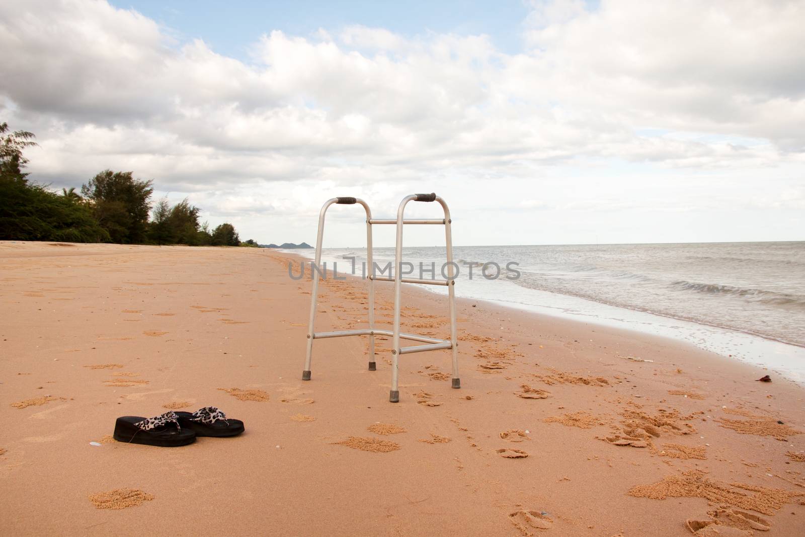 walker on sand beach. convey in meaning the relax tourist attractions of the elderly.