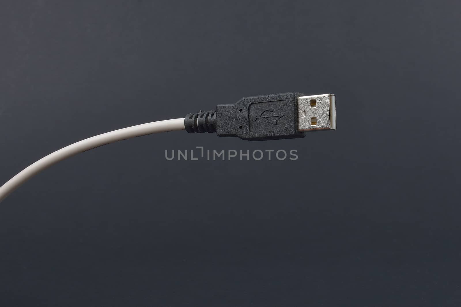 USB Cable Plug  on dark background by constantinhurghea